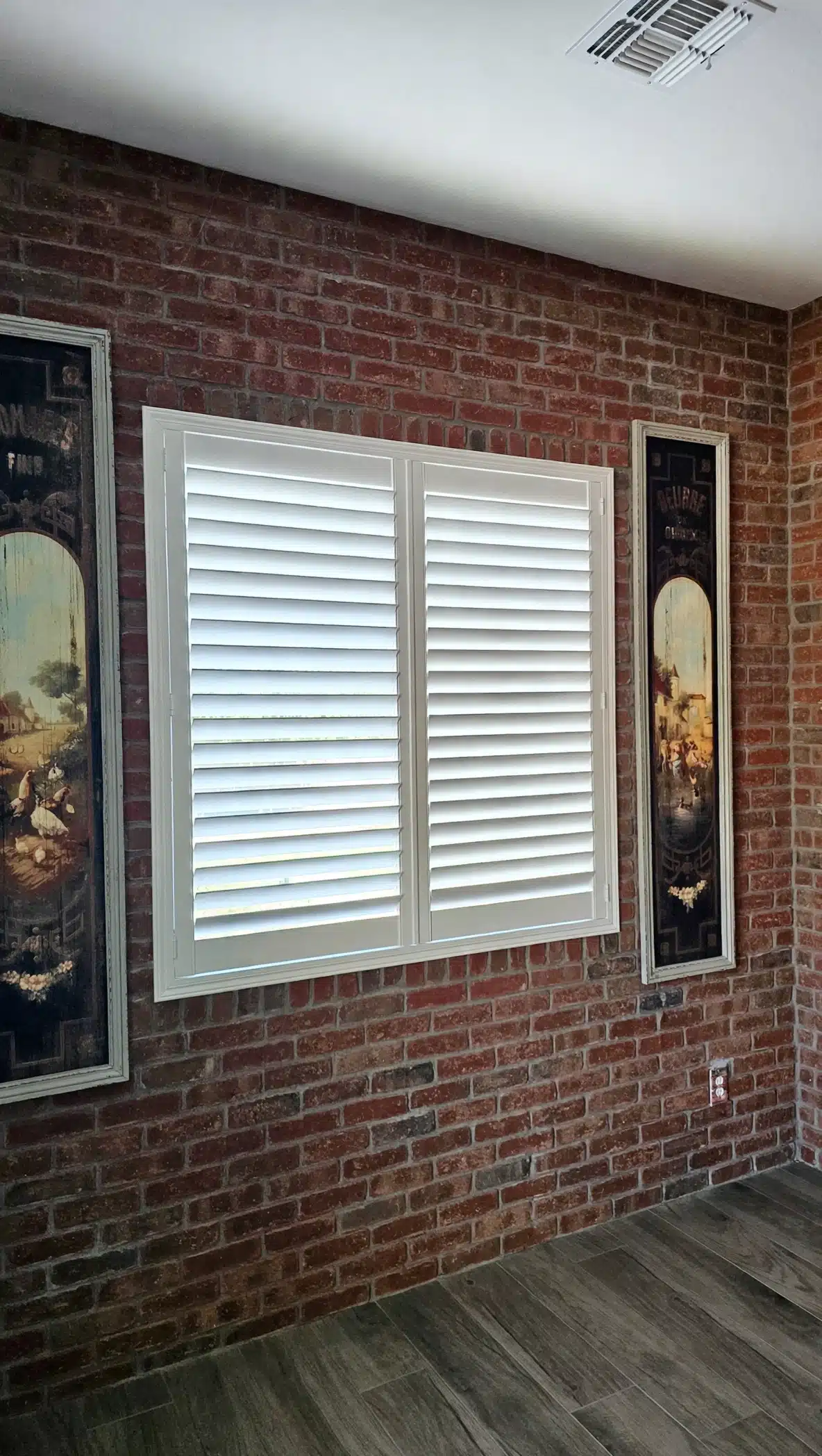 Composite white plantation shutter in Prescott AZ in a Dining Room on brick.