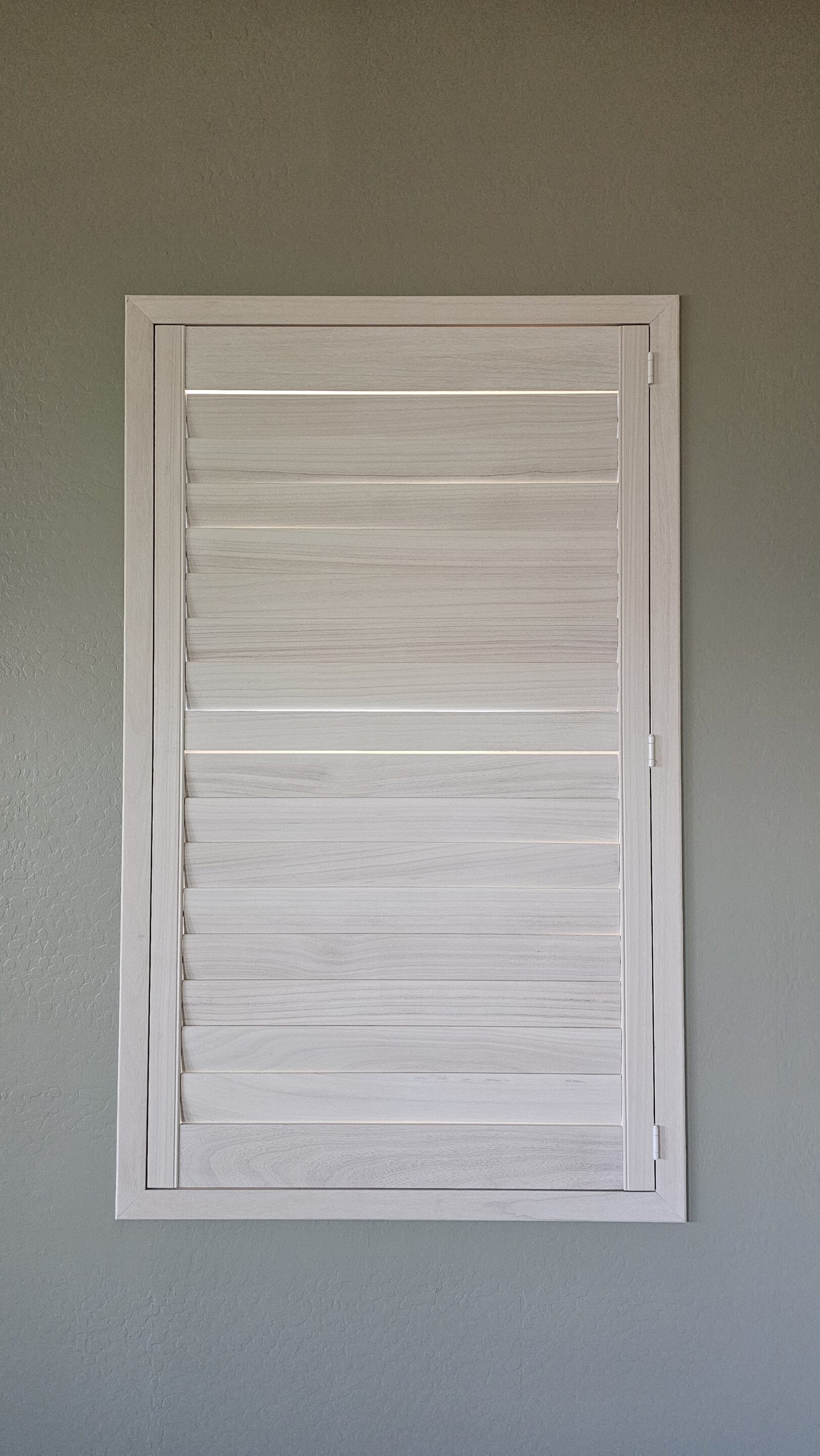 Hardwood shutter in a window with light stain in Prescott Arizona.